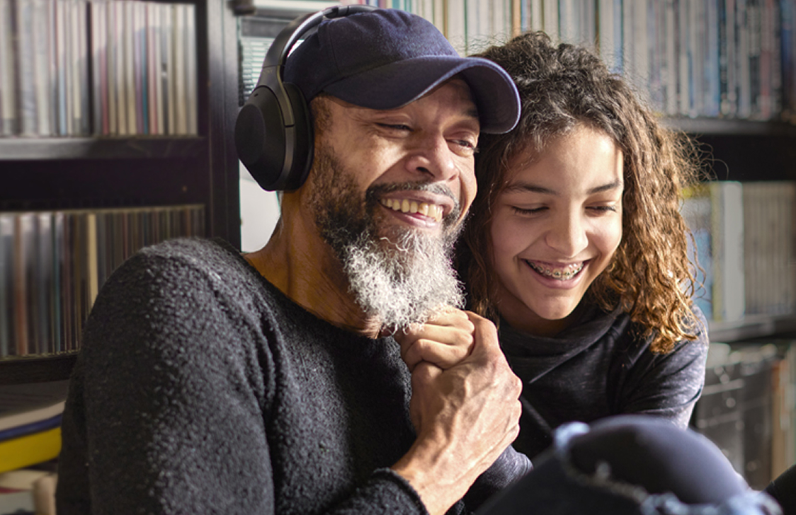 Father and daughter listening to music together on headphones